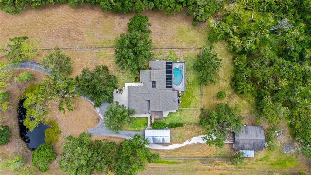 An aerial view shows a house with a pool, a pond, and a detached building — 140 COWPEN LANE, SARASOTA, FL