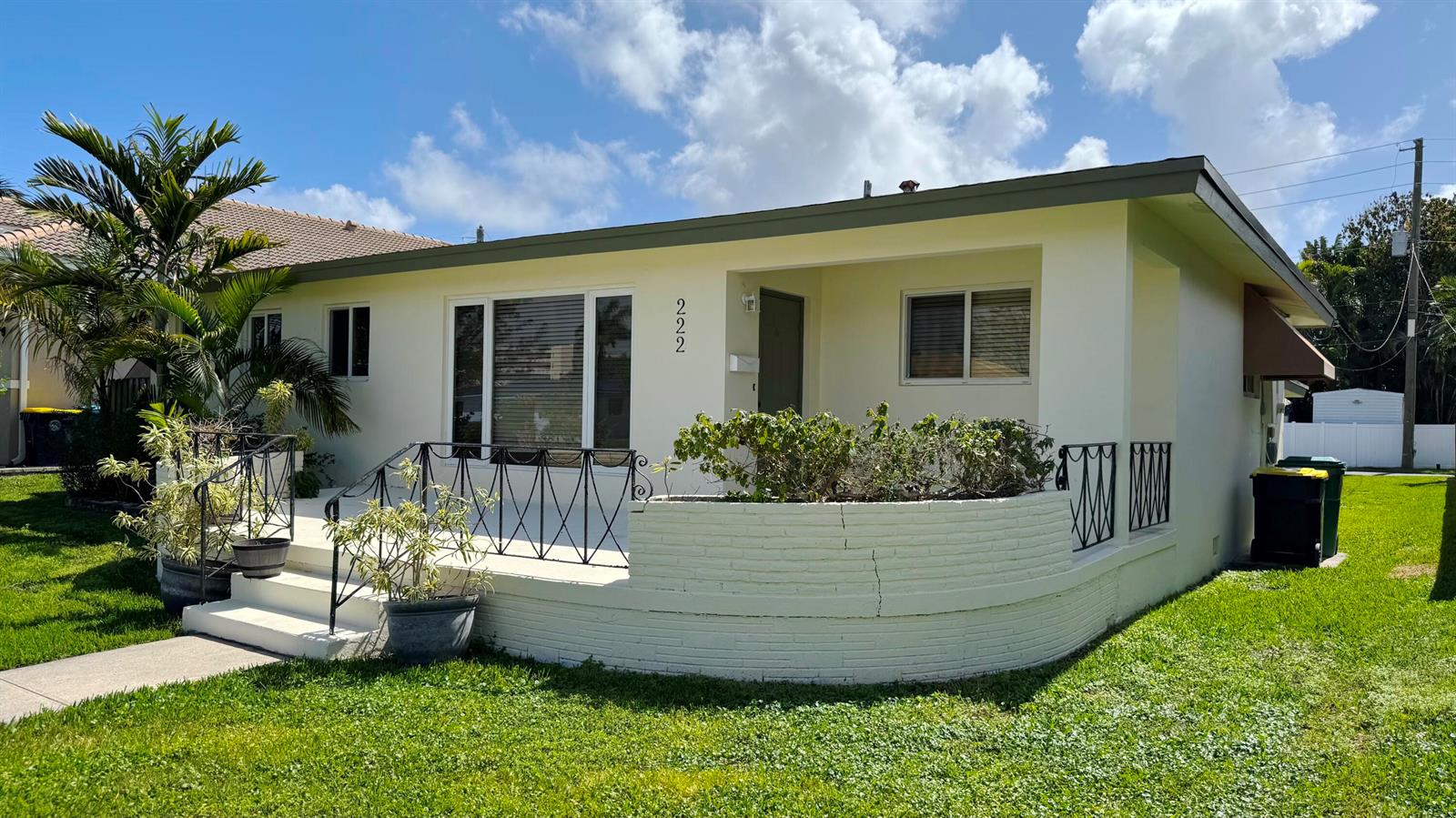 A single-story house with a white painted brick porch, metal railings, and a palm tree — 222 SE 2nd Terrace, Dania Beach FL 33004, DANIA BEACH, FL