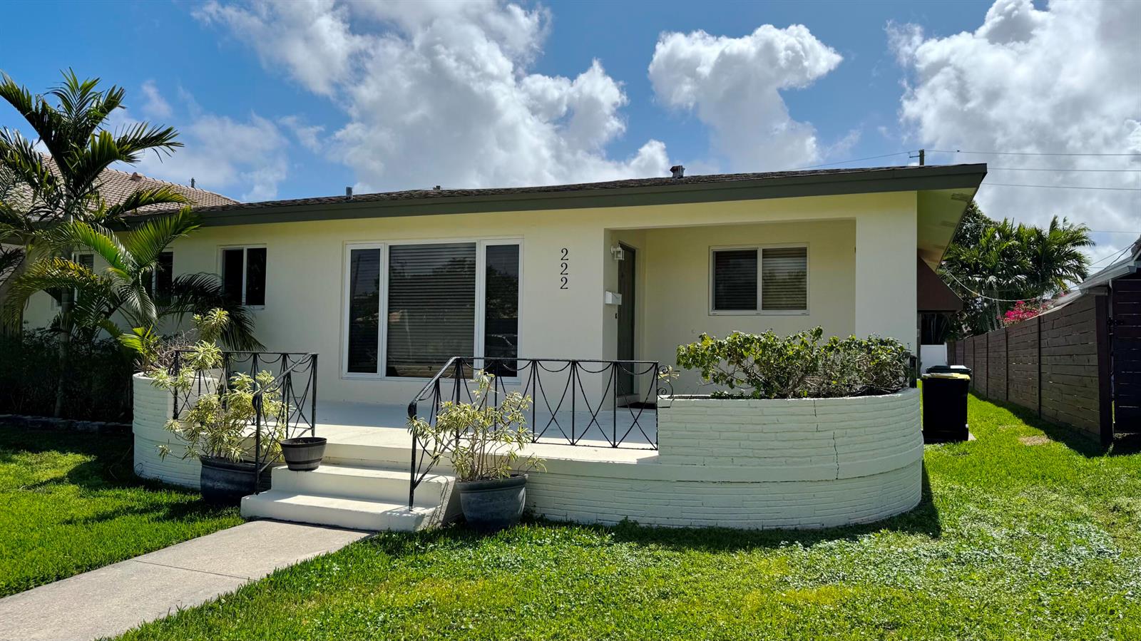 A single-story house with a white brick porch, metal railing, and a front lawn — 222 SE 2nd Terrace, Dania Beach FL 33004, DANIA BEACH, FL