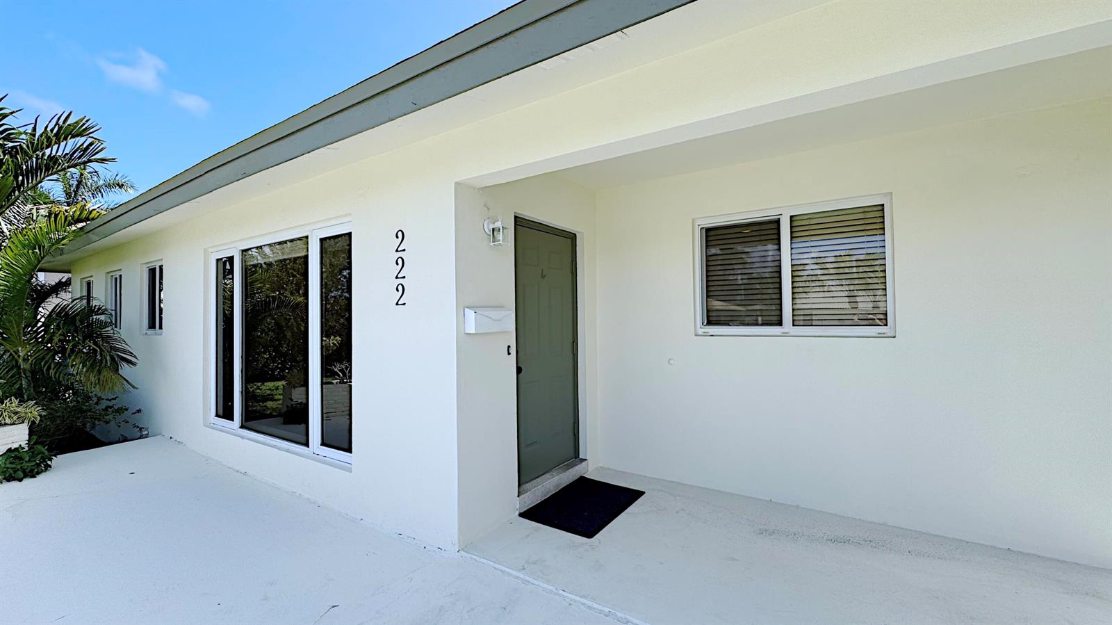 The exterior of a white house features a green front door and a house number — 222 SE 2nd Terrace, Dania Beach FL 33004, DANIA BEACH, FL