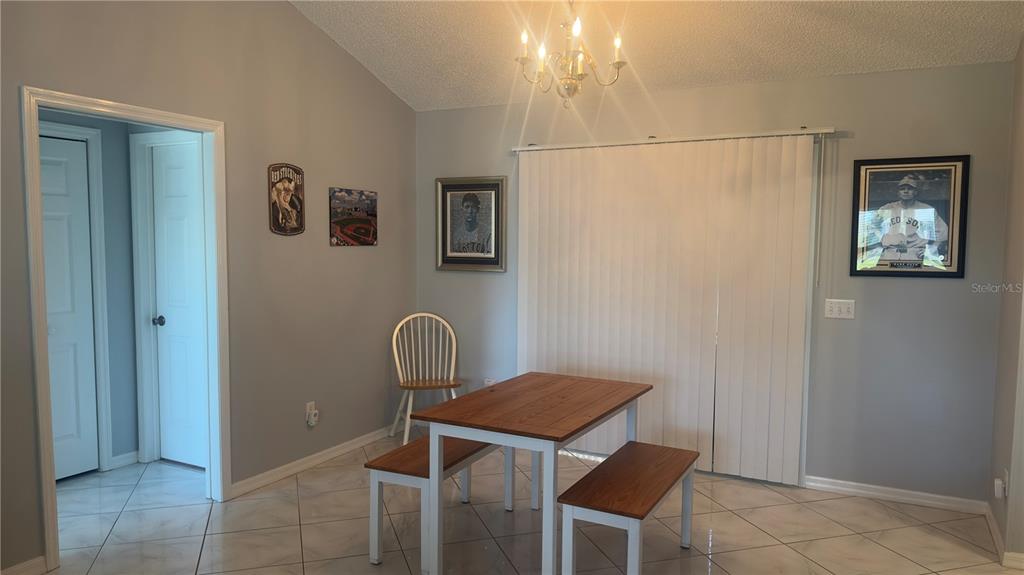 A dining area features a wooden table with two benches, a chair, and tiled flooring — 2259 MARGARITA DRIVE, THE VILLAGES, FL