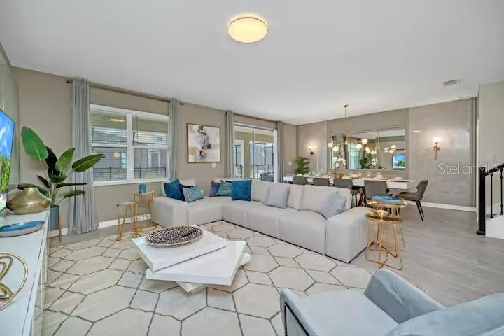 A living room features a large sectional sofa, a geometric rug, and a dining area — 2854 BOOKMARK DRIVE, KISSIMMEE, FL
