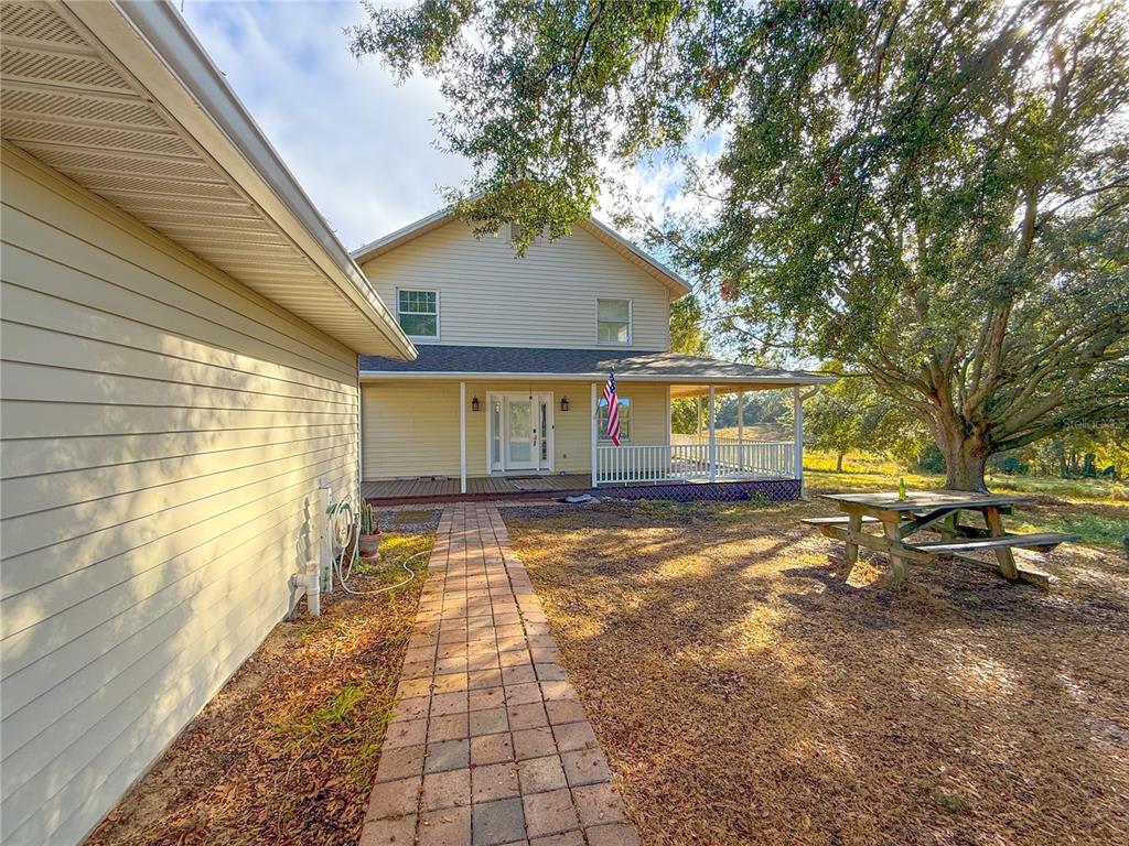 A two-story house with beige siding, a front porch, and a brick walkway — 2827 SANCTUARY LANE, WINTER GARDEN, FL