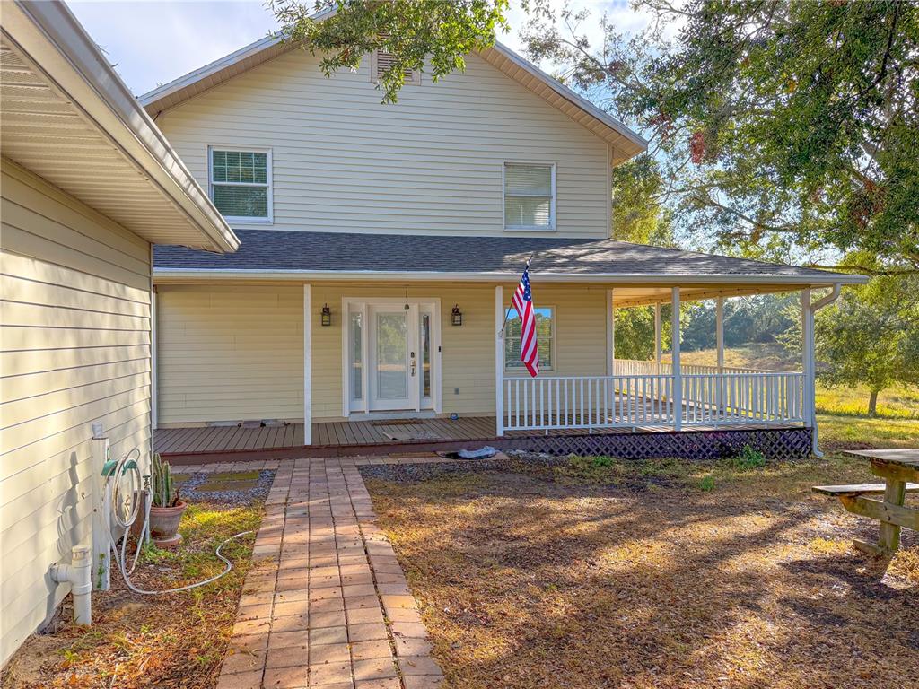 A two-story house with light yellow siding, a front porch, and a brick walkway — 2827 SANCTUARY LANE, WINTER GARDEN, FL
