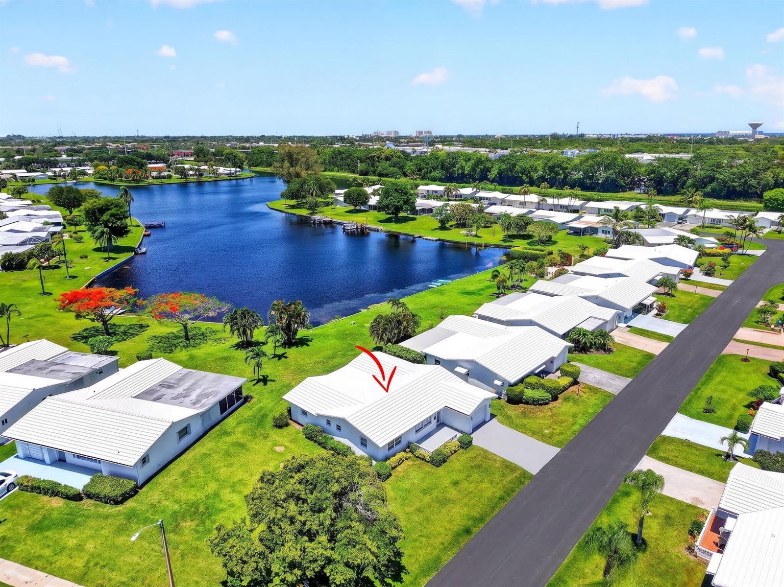 An aerial view shows a white house with a metal roof near a large lake — 1213 SW 20th Avenue, Boynton Beach FL 33426, BOYNTON BEACH, FL