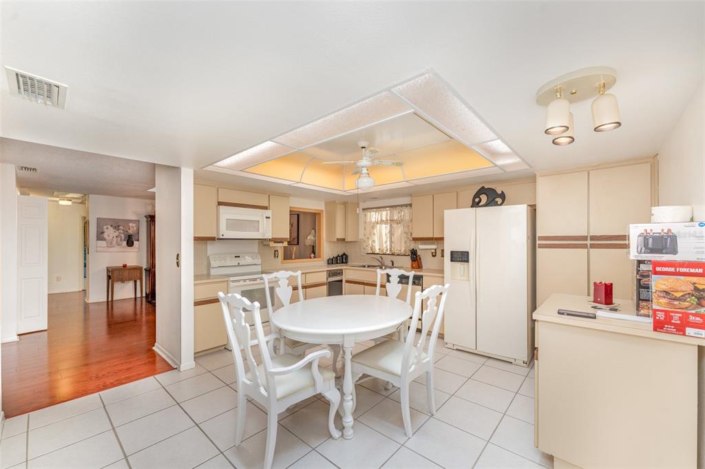 A kitchen with white cabinets, a round dining table, and a recessed ceiling light fixture — 4240 CREEKWOOD LANE, MULBERRY, FL