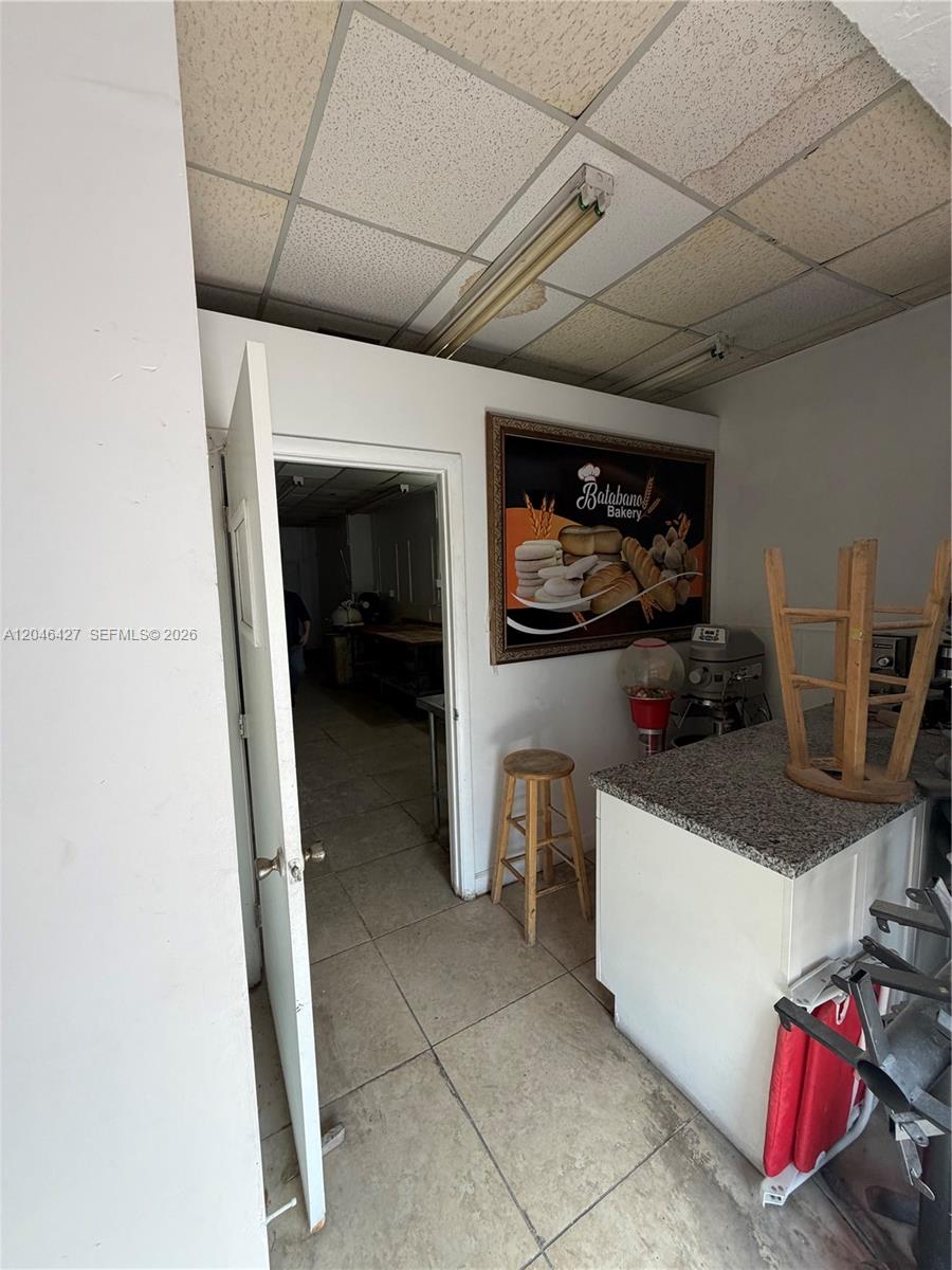 A small bakery interior features a service counter, a wooden stool, and a doorway — 1262 Palm Ave, Hialeah FL 33010, HIALEAH, FL
