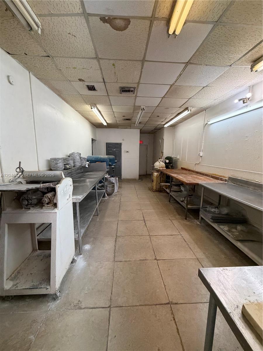 A commercial kitchen features stainless steel prep tables, industrial equipment, and a drop ceiling — 1262 Palm Ave, Hialeah FL 33010, HIALEAH, FL