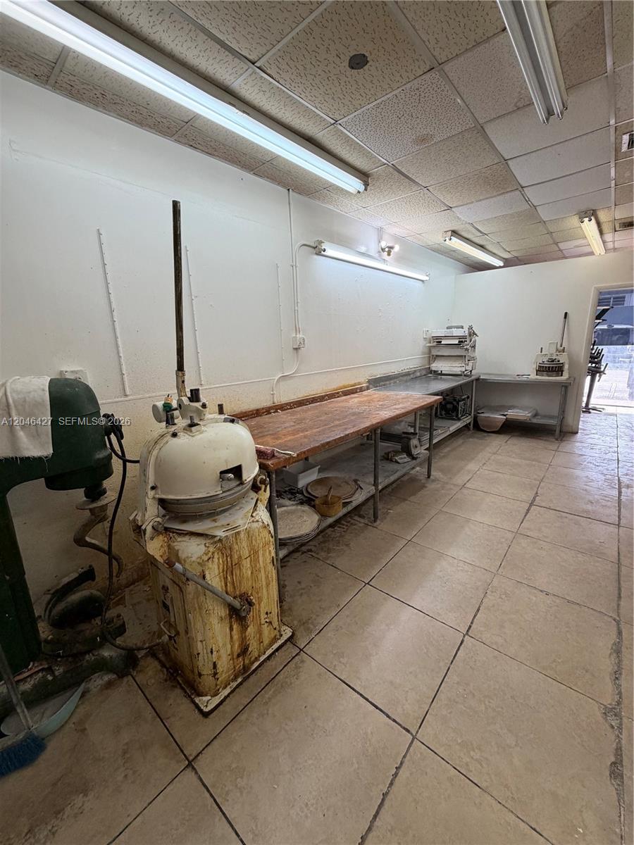 A commercial kitchen features a large dough divider, a wooden prep table, and tiled floors — 1262 Palm Ave, Hialeah FL 33010, HIALEAH, FL