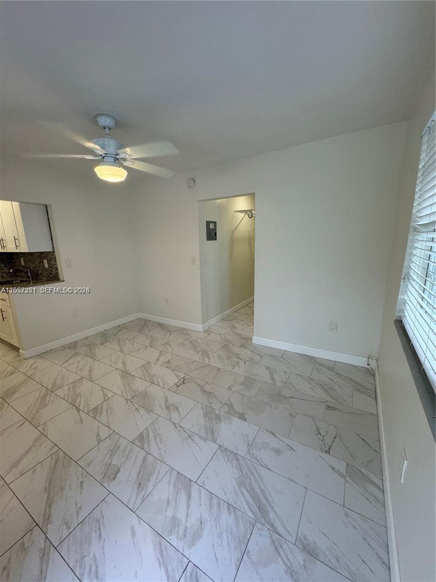 A room with white marble-patterned tile flooring, a ceiling fan, and an open doorway — 11890 NE 16th Ave # 6, Miami FL 33161, MIAMI, FL