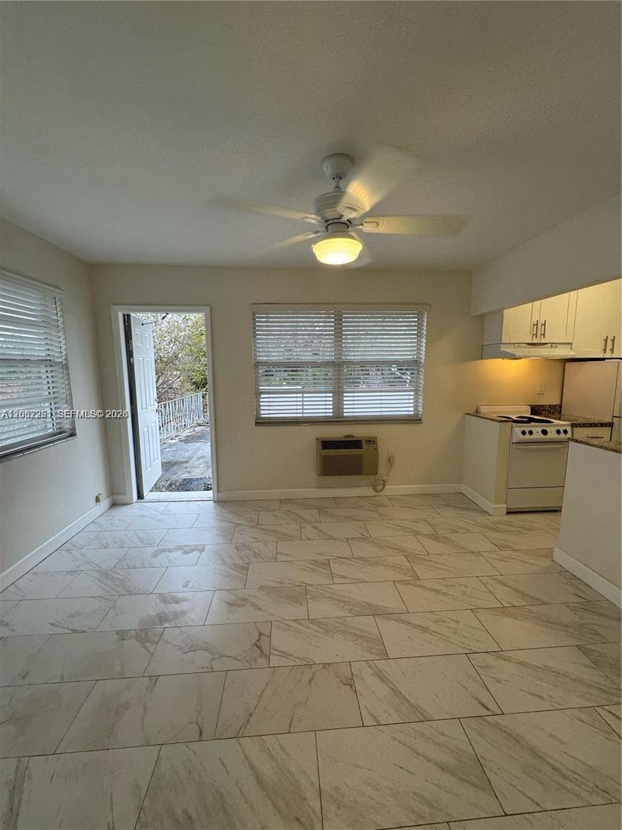 An open-concept kitchen and living area features light-colored tile flooring and a ceiling fan — 11890 NE 16th Ave # 6, Miami FL 33161, MIAMI, FL