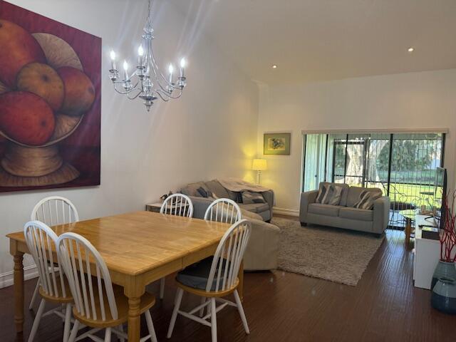 A dining area with a wooden table and chandelier opens into a living room space — 8458 Boca Glades Boulevard E, Boca Raton FL 33434, BOCA RATON, FL