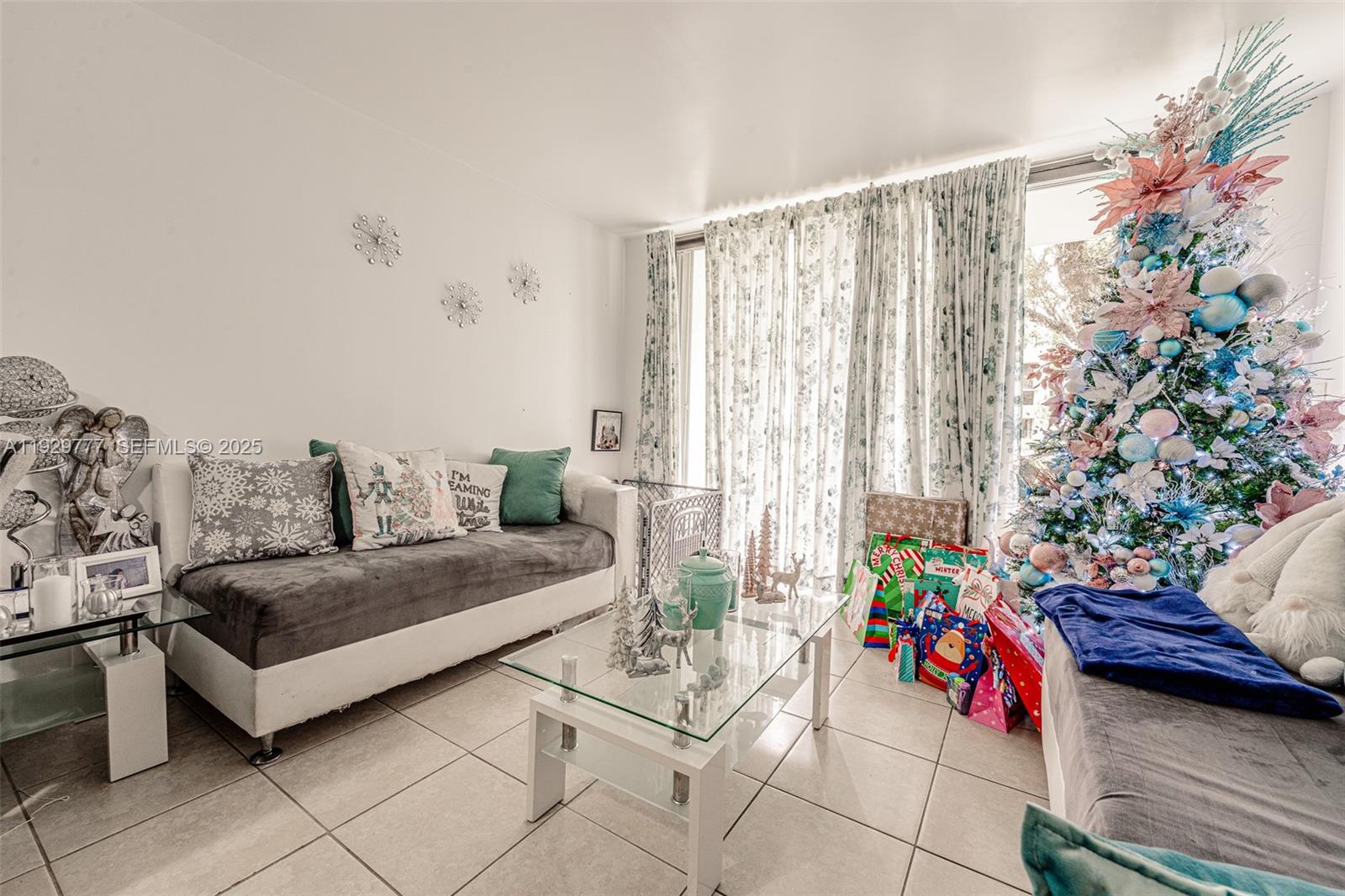 A living room features a sofa, a glass coffee table, and a decorated Christmas tree — 8006 SW 149th Ave # D109, Miami FL 33193, MIAMI, FL