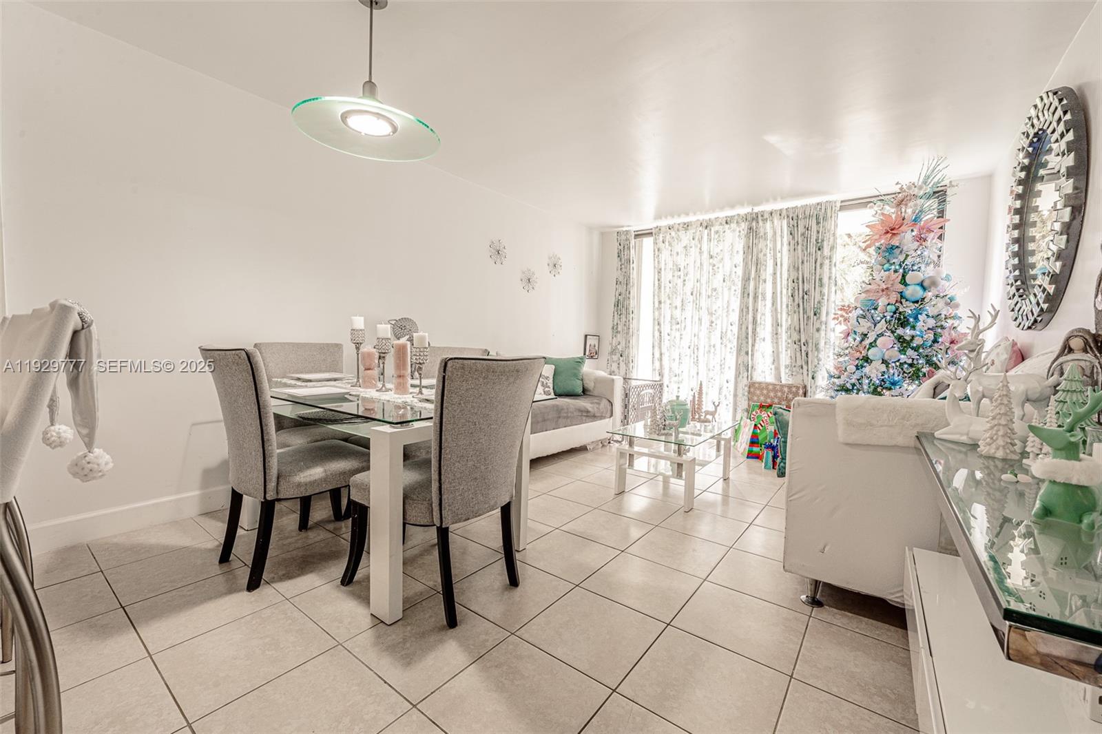 A dining and living area features tile floors, a glass-top table, and holiday decorations — 8006 SW 149th Ave # D109, Miami FL 33193, MIAMI, FL