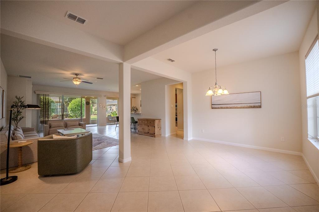 An open-concept living and dining area features tile flooring, neutral walls, and a ceiling fan — 9876 SW 69TH LANE, OCALA, FL