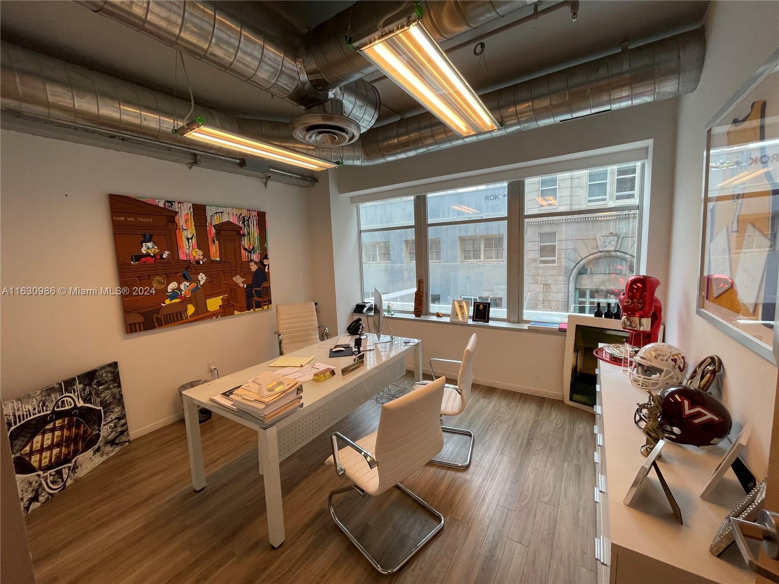 A modern office features a white desk, two chairs, exposed ductwork, and sports memorabilia — 14 NE 1st Ave # 300A, Miami FL 33132, MIAMI, FL