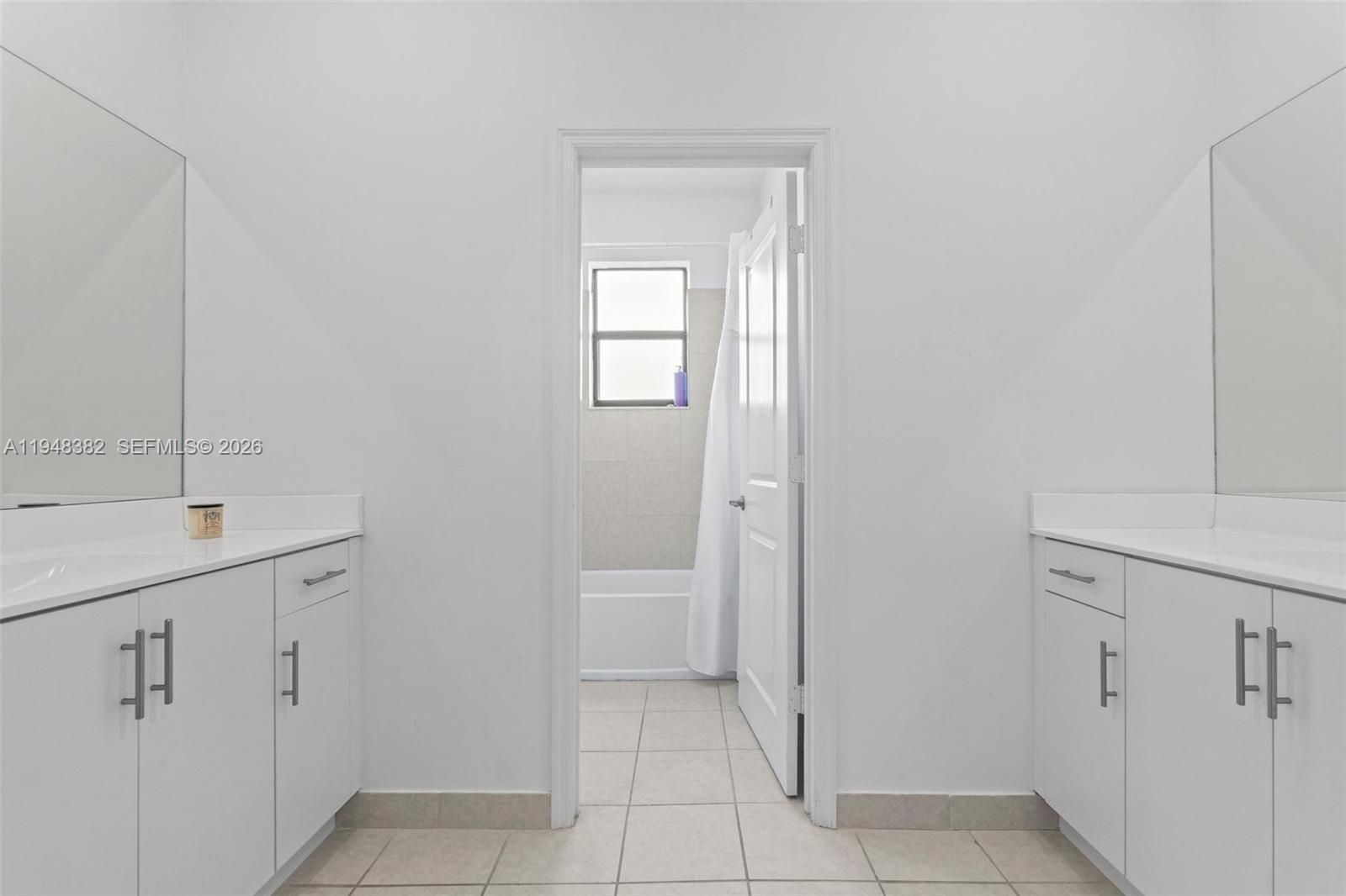 A bathroom features dual white vanities with mirrors and a separate tub and shower area — 12927 SW 229th Ter, Miami FL 33170, MIAMI, FL