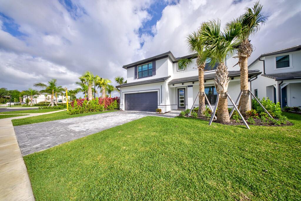 A two-story white house with a gray garage, paved driveway, and palm trees in front — 9721 Chora Tunel Way, Lake Worth FL 33467, LAKE WORTH, FL