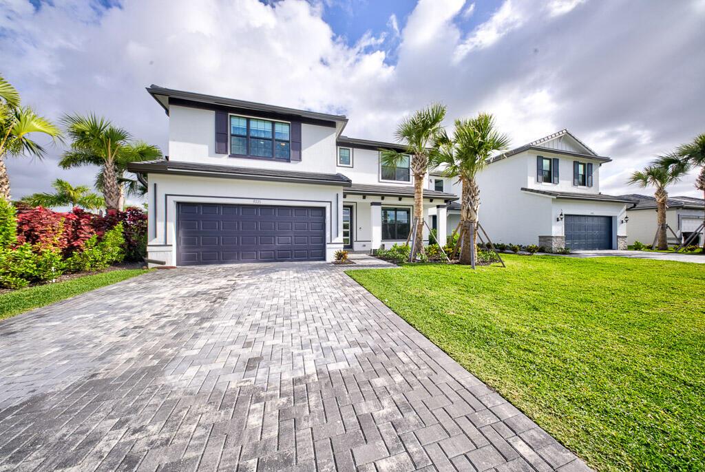 A two-story white house with a gray garage and a paved driveway under a cloudy sky — 9721 Chora Tunel Way, Lake Worth FL 33467, LAKE WORTH, FL