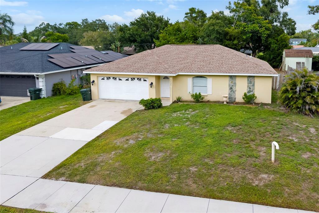 An exterior view of a single-story house with a tan facade and a shingled roof — 5000 MINK ROAD, SARASOTA, FL