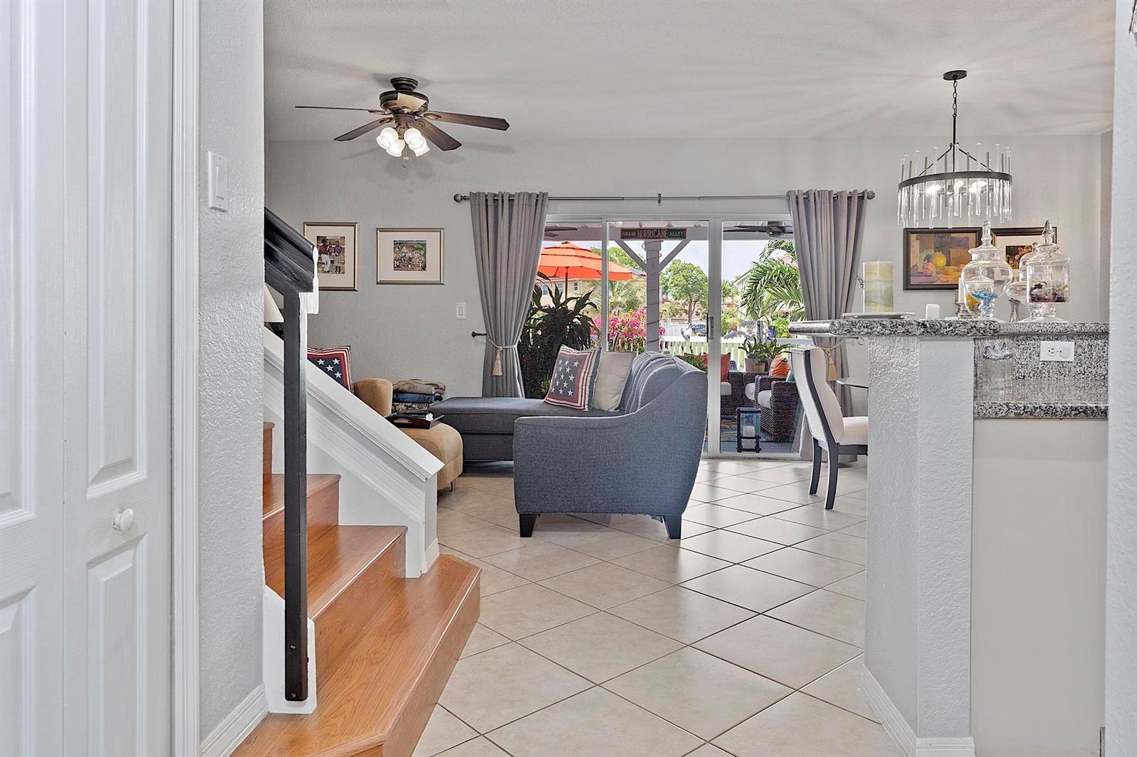 A living room with tile floors, a staircase, and a sliding door to a patio — 12955 SW 28TH Court, Miramar FL 33027, MIRAMAR, FL