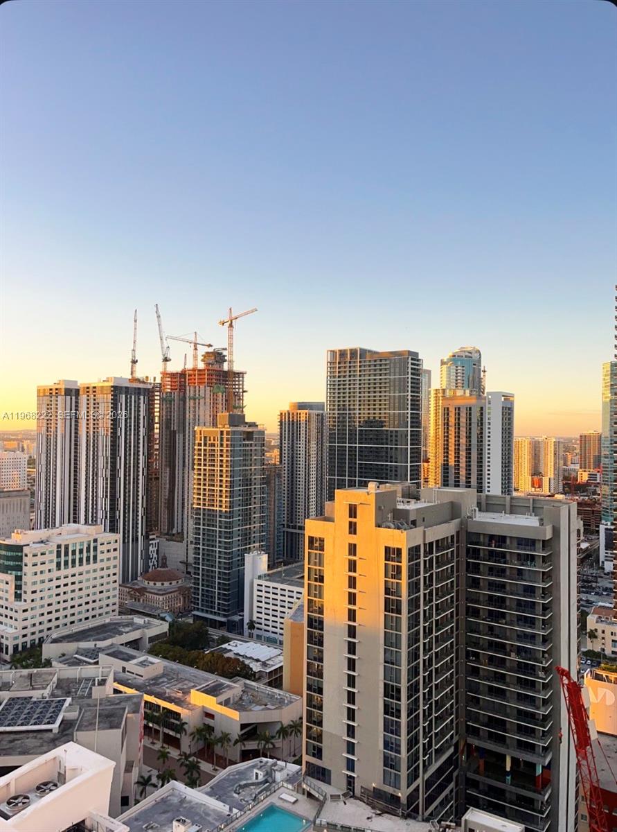 An elevated view of a dense city skyline featuring multiple high-rise buildings and construction cranes — 253 NE 2nd St # 3903, Miami FL 33132, MIAMI, FL