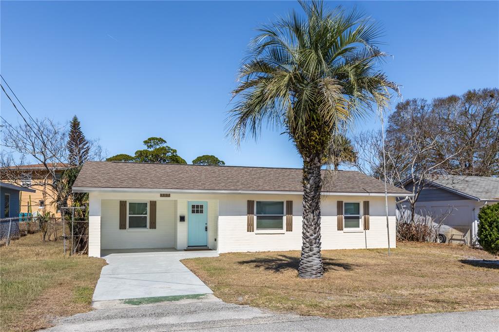 A single-story house with a light-colored brick exterior, a palm tree, and a driveway — 307 LEGION PLACE, PORT ORANGE, FL