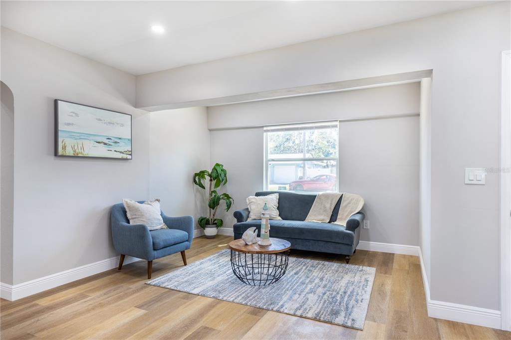 A living room features a blue sofa, matching armchair, coffee table, and light wood flooring — 307 LEGION PLACE, PORT ORANGE, FL