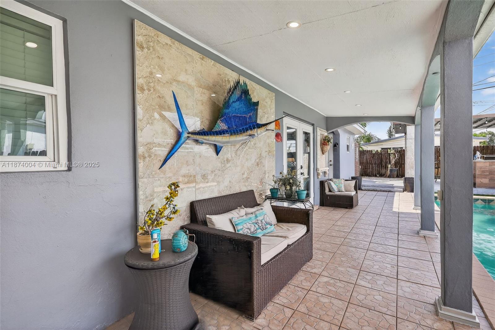 An entryway features a large arched glass block window, dark blue walls, and wood-look flooring — 7120 Wilson St, Hollywood FL 33024, HOLLYWOOD, FL