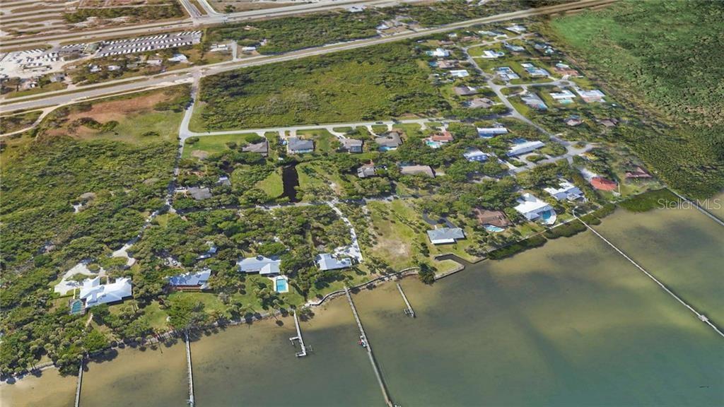An aerial view shows waterfront houses with private docks along a coastal residential area — 0 MILTON ROAD & RIVER WOODS DRIVE, FORT PIERCE, FL
