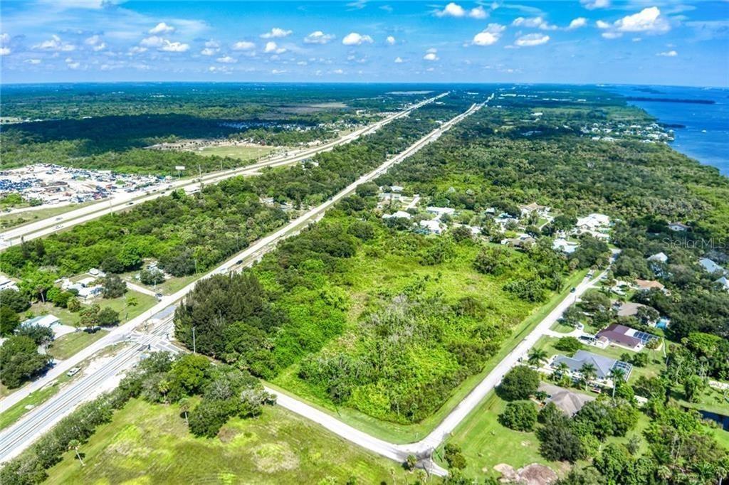An aerial view shows a vacant, tree-covered lot bordered by roads and nearby residential homes — 0 MILTON ROAD & RIVER WOODS DRIVE, FORT PIERCE, FL