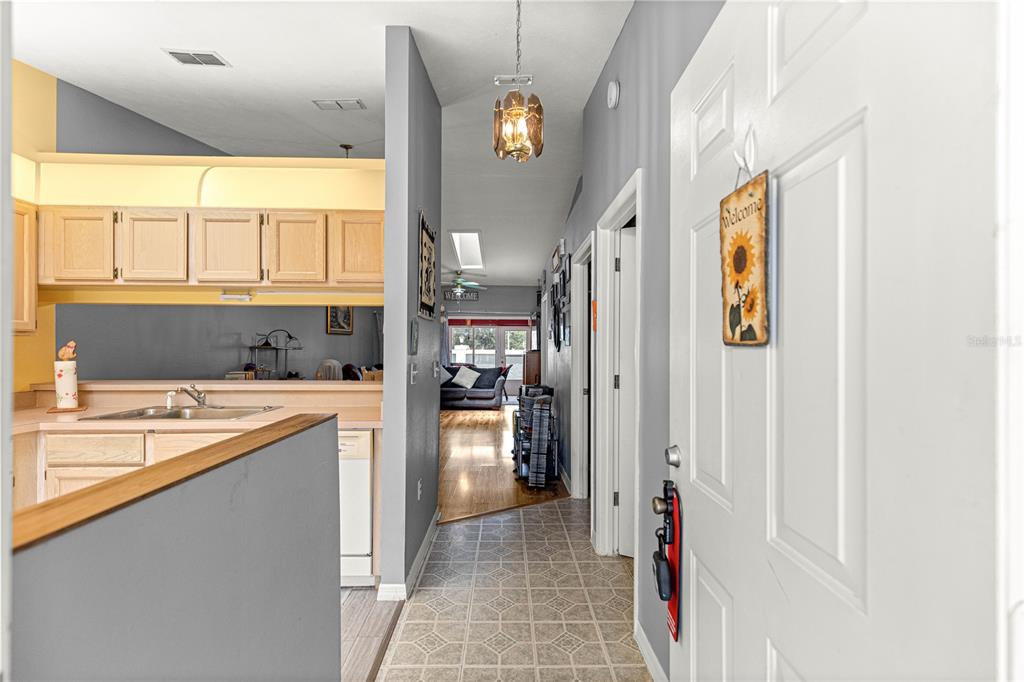 A view from an entryway looking down a hallway toward a living room and kitchen — 10483 SW 85TH COURT, OCALA, FL