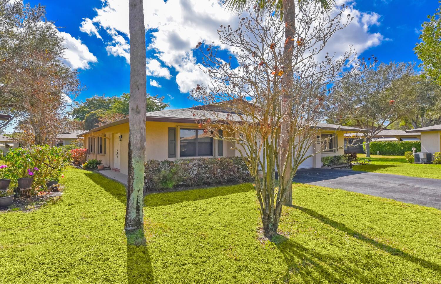 A single-story house with a beige exterior, a dark roof, and a paved driveway — 1630 Palmland Drive, Boynton Beach FL 33436, BOYNTON BEACH, FL