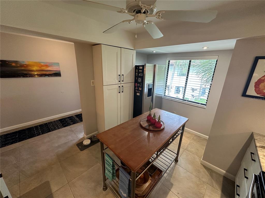 A kitchen features a wooden island, a tall pantry cabinet, and a stainless steel refrigerator — 3500 EL CONQUISTADOR PARKWAY UNIT 344, BRADENTON, FL