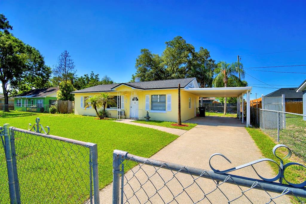 A yellow single-story house with a white front door and a concrete driveway carport — 1306 BRYN MAWR AVENUE, LAKE WALES, FL
