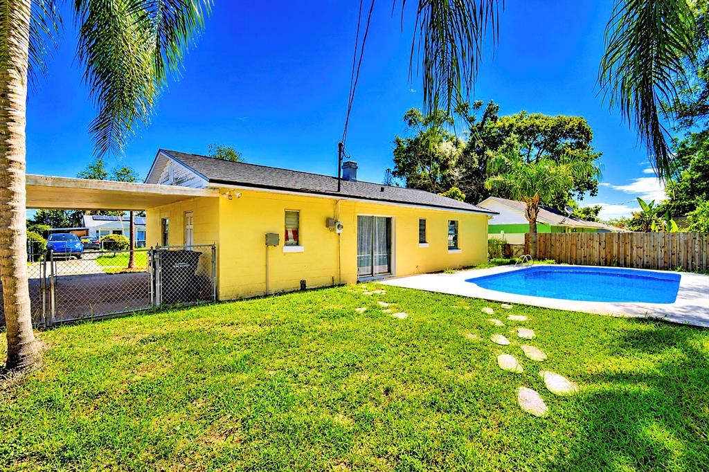 A yellow house with a carport and a swimming pool in the backyard — 1306 BRYN MAWR AVENUE, LAKE WALES, FL