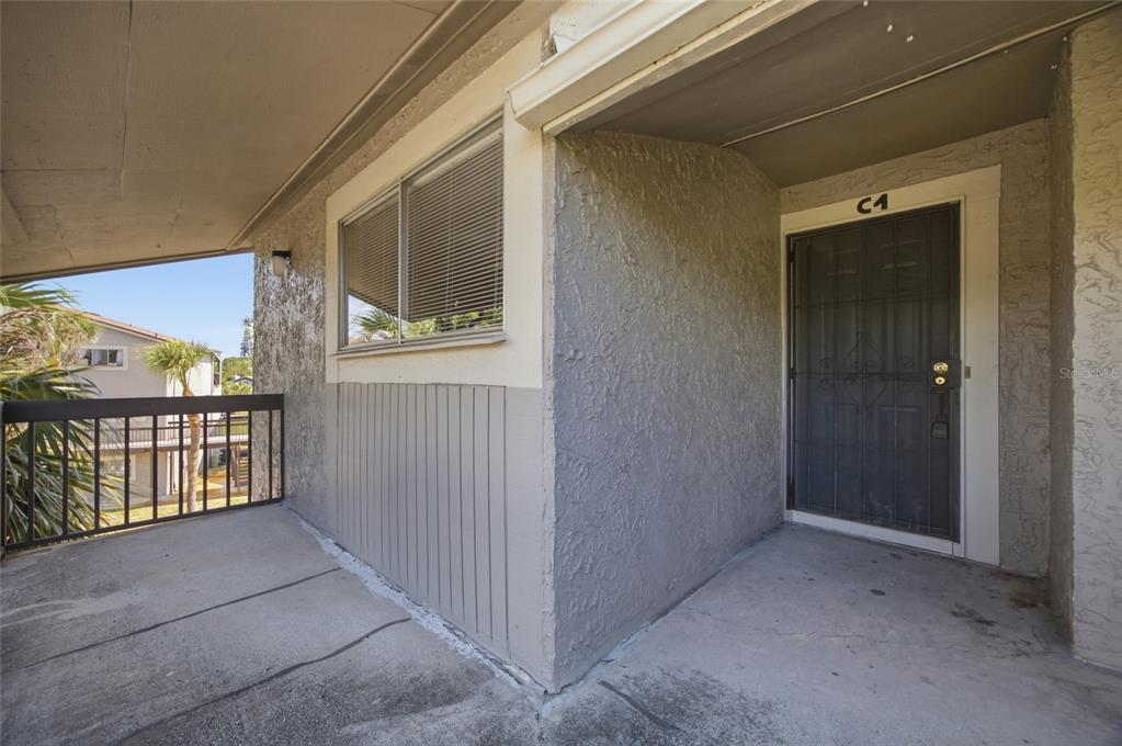 An exterior view of a covered apartment balcony with a screen door labeled C4 — 6336 NEWTOWN CIRCLE UNIT 36C1, TAMPA, FL