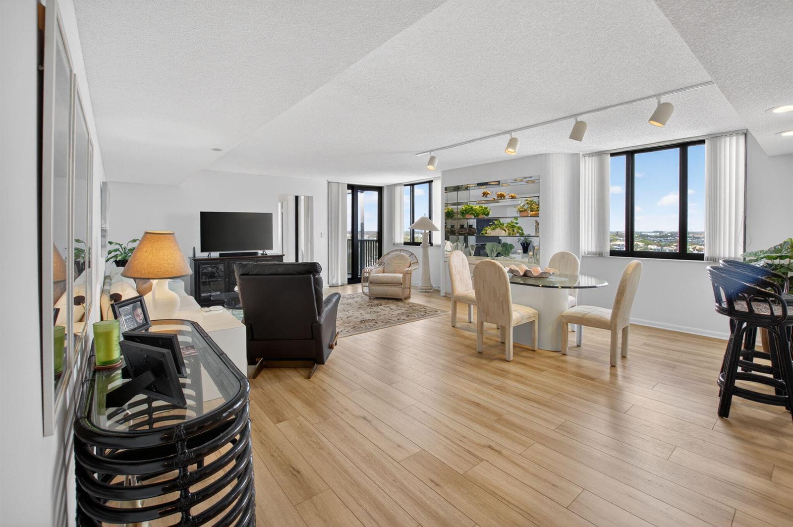 A bright, open-concept living and dining area with light wood flooring and floor-to-ceiling windows — 3420 S Ocean Boulevard # 12t, Highland Beach FL 33487, HIGHLAND BEACH, FL