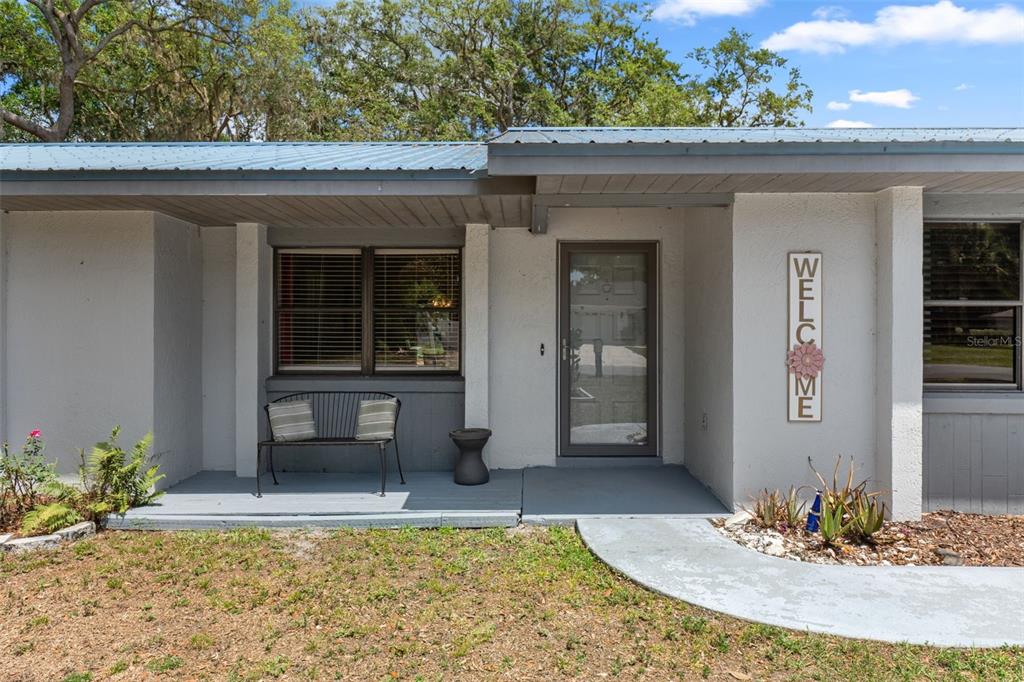 The exterior of a single-story home features a gray porch, a front door, and windows — 2481 S SUMMERWOOD POINT, INVERNESS, FL