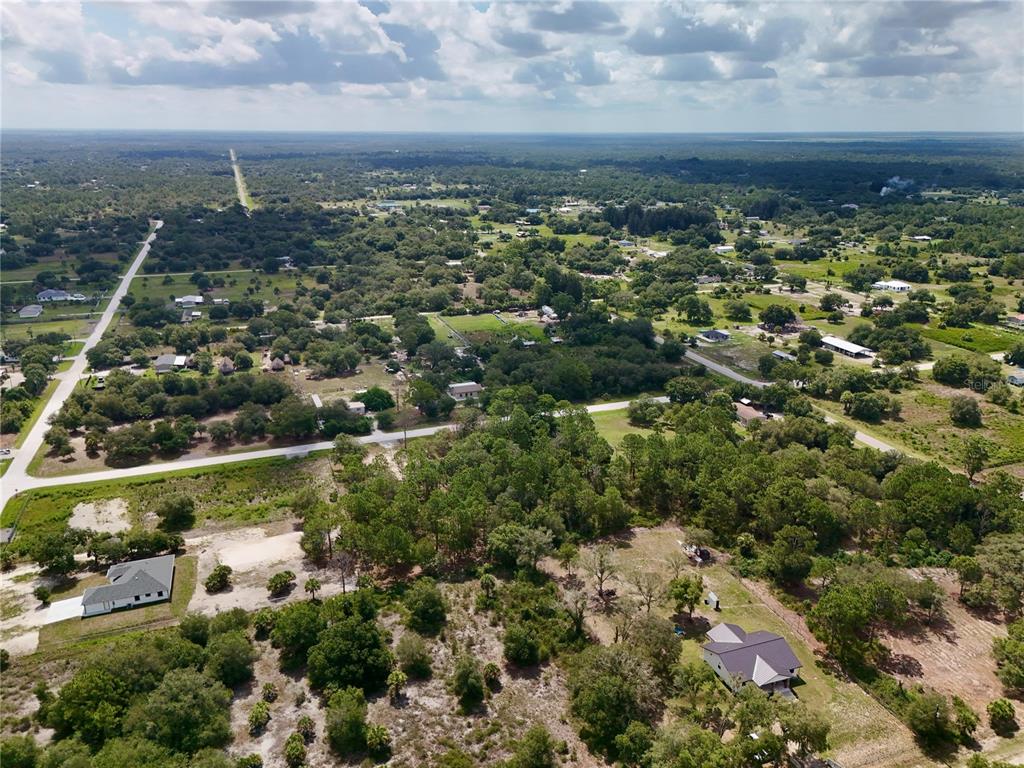 An aerial view shows a rural landscape with scattered houses, trees, and intersecting paved roads — 270 N DATIL STREET, CLEWISTON, FL