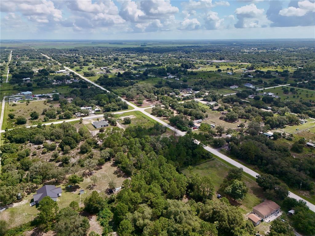 An aerial view shows a rural landscape with scattered houses, wooded areas, and intersecting roads — 270 N DATIL STREET, CLEWISTON, FL