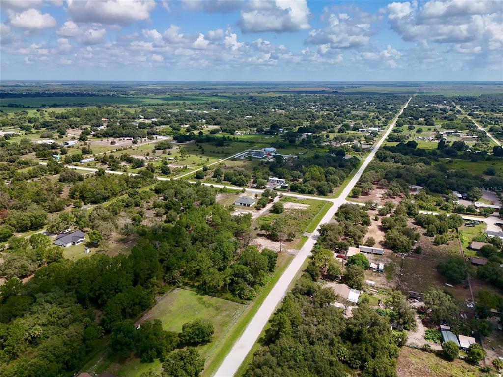 An aerial view shows a rural landscape with scattered houses, wooded areas, and intersecting roads — 270 N DATIL STREET, CLEWISTON, FL