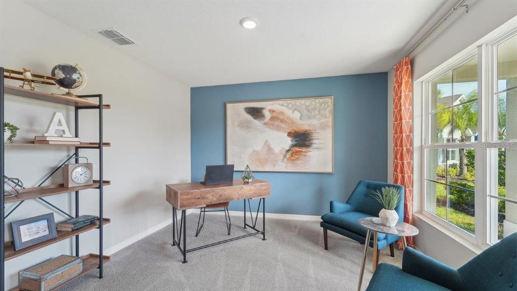 A home office features a wood desk, blue accent wall, two armchairs, and a bookshelf — 35101 VALLEY RIDGE ROAD, DADE CITY, FL
