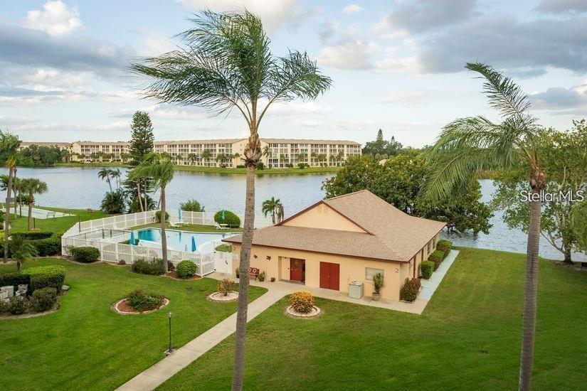 An aerial view shows a community clubhouse with a pool, palm trees, and a lake — 4105 LAKE BAYSHORE DRIVE, BRADENTON, FL