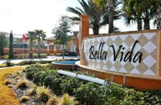 A stone sign with the text Bella Vida stands in front of a gated community entrance — 4564 ADA LANE, KISSIMMEE, FL