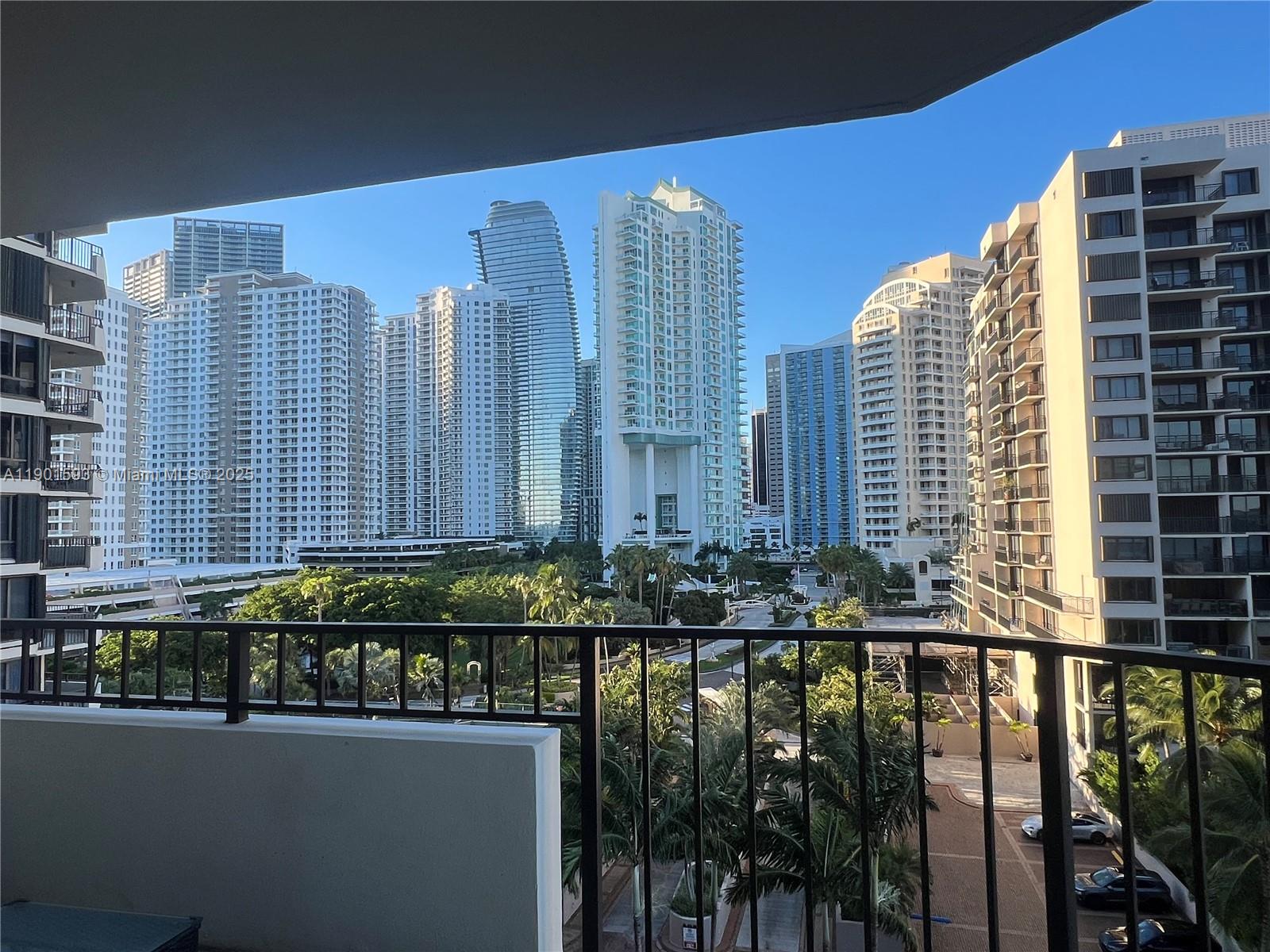 A balcony overlooks a dense urban landscape of high-rise apartment buildings and palm trees — 520 Brickell Key Dr # A900, Miami FL 33131, MIAMI, FL