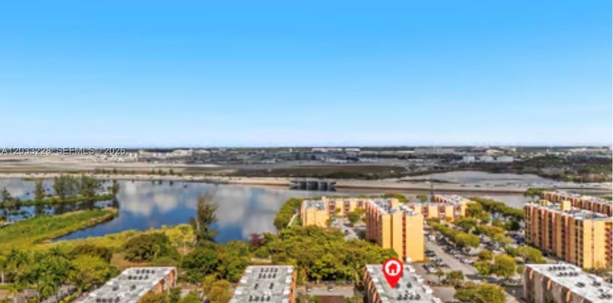 An aerial view shows several multi-story apartment buildings situated near a lake and a highway — 4841 NW 7th St # 4, Miami FL 33126, MIAMI, FL