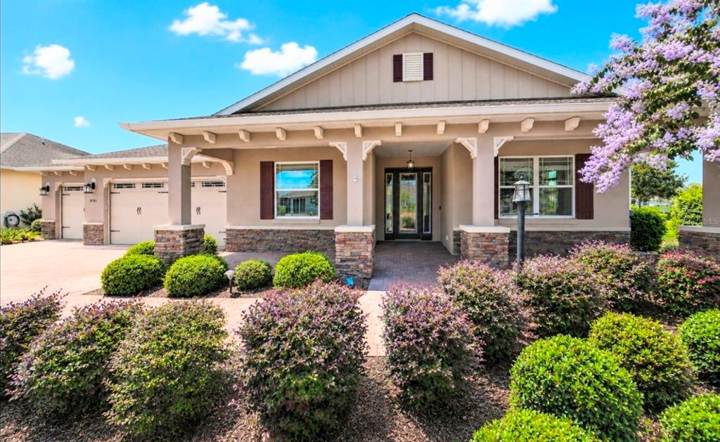 A single-story house with a stone-accented facade, a covered porch, and a paved driveway — 8761 SW 93RD CIRCLE, OCALA, FL