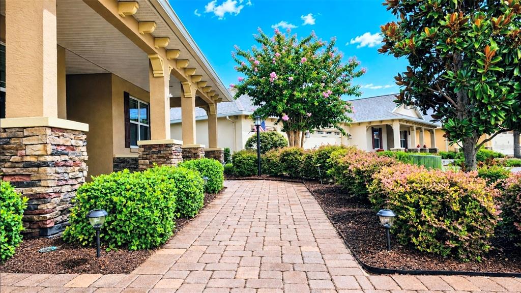 A stone-paved walkway leads to the entrance of a house with a covered porch — 8761 SW 93RD CIRCLE, OCALA, FL