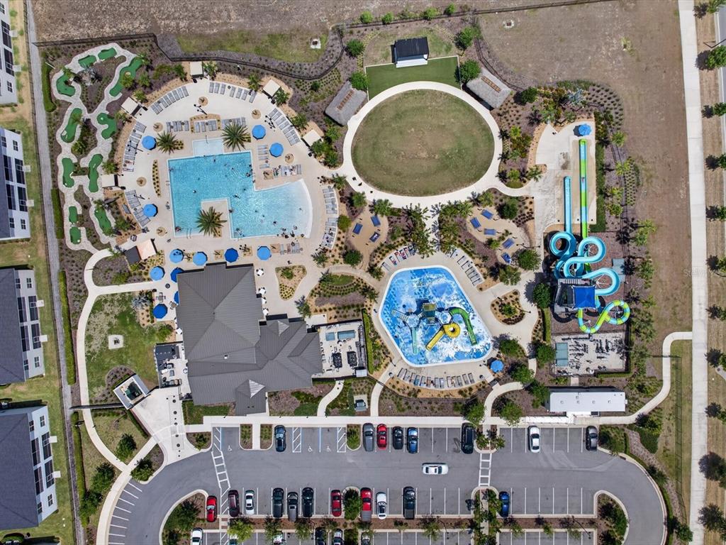 An aerial view shows a community pool complex with water slides, a splash pad, and parking — 967 SPLASH SHOT PLACE UNIT 2503, DAVENPORT, FL